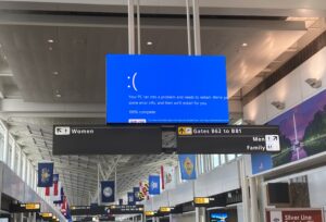 Bild eines Flughafenterminals mit einem Bluescreen auf einem grossen Infobildschirm