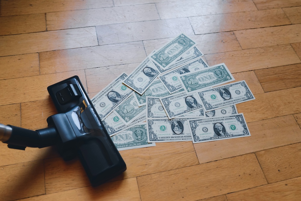 Ein Staubsauger saugt Dollarnoten ein