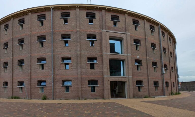 Ein rundes Backsteingebäude mit vielen regelmässig angeordneten Fenstern