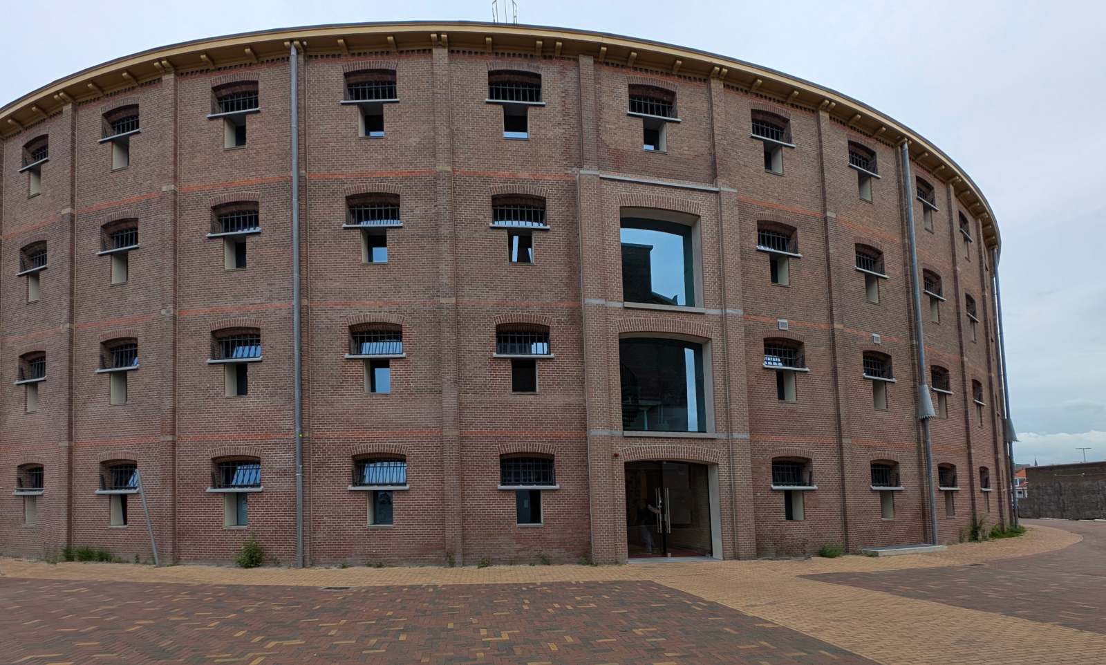 Ein rundes Backsteingebäude mit vielen regelmässig angeordneten Fenstern
