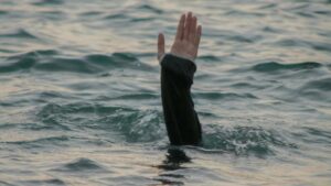 Eine Hand die aus dem Wasser winkt