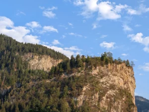 Haus oberhalb eines bewaldeten Steilhangs